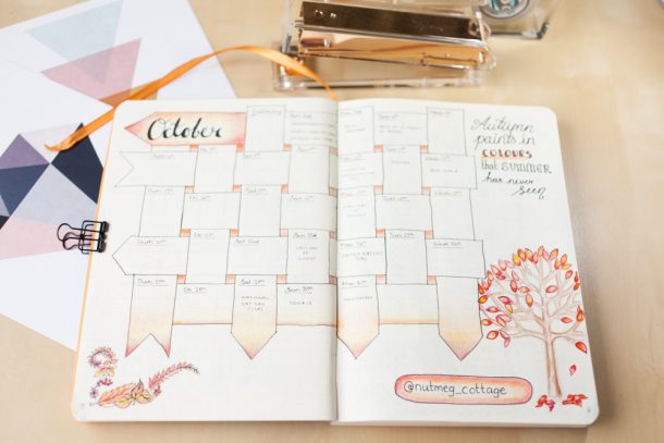 An October calendar spread in a bullet journal with autumnal leaf illustrations and warm colour tones.